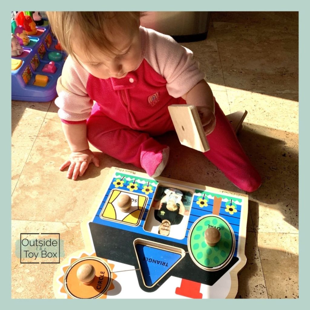 Baby using peg puzzle with pictures