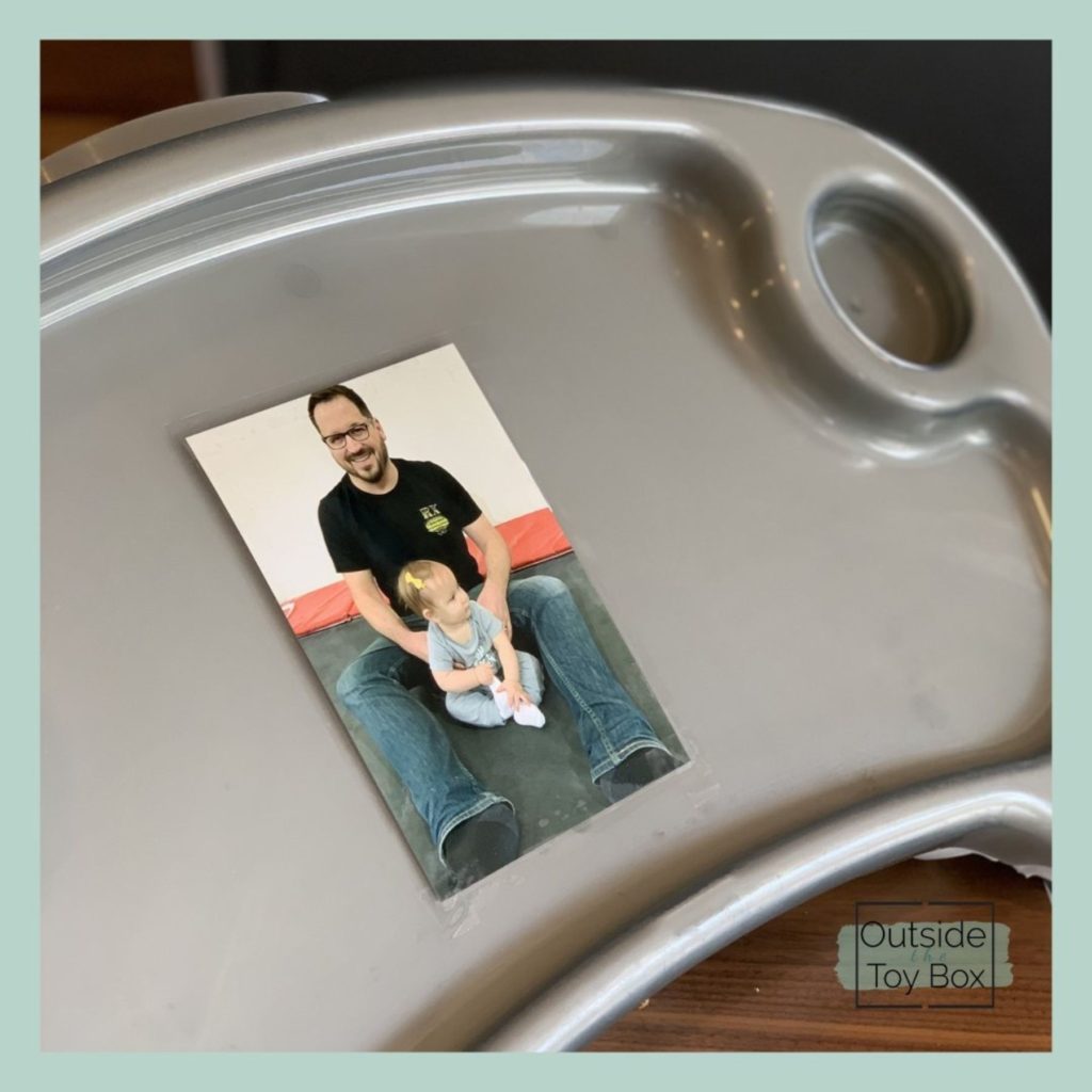 Picture of man and baby taped to high chair tray