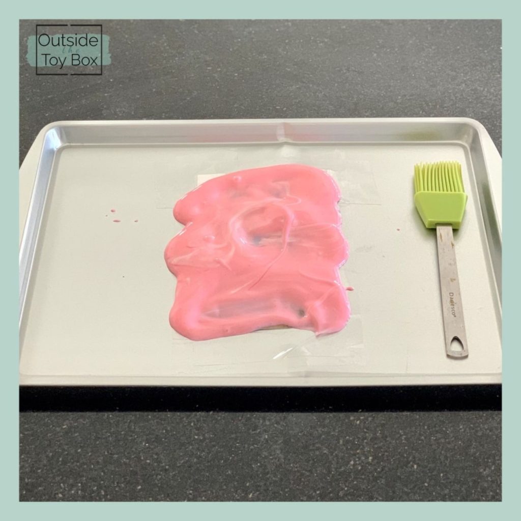 Pink yogurt covering picture on tray with basting brush
