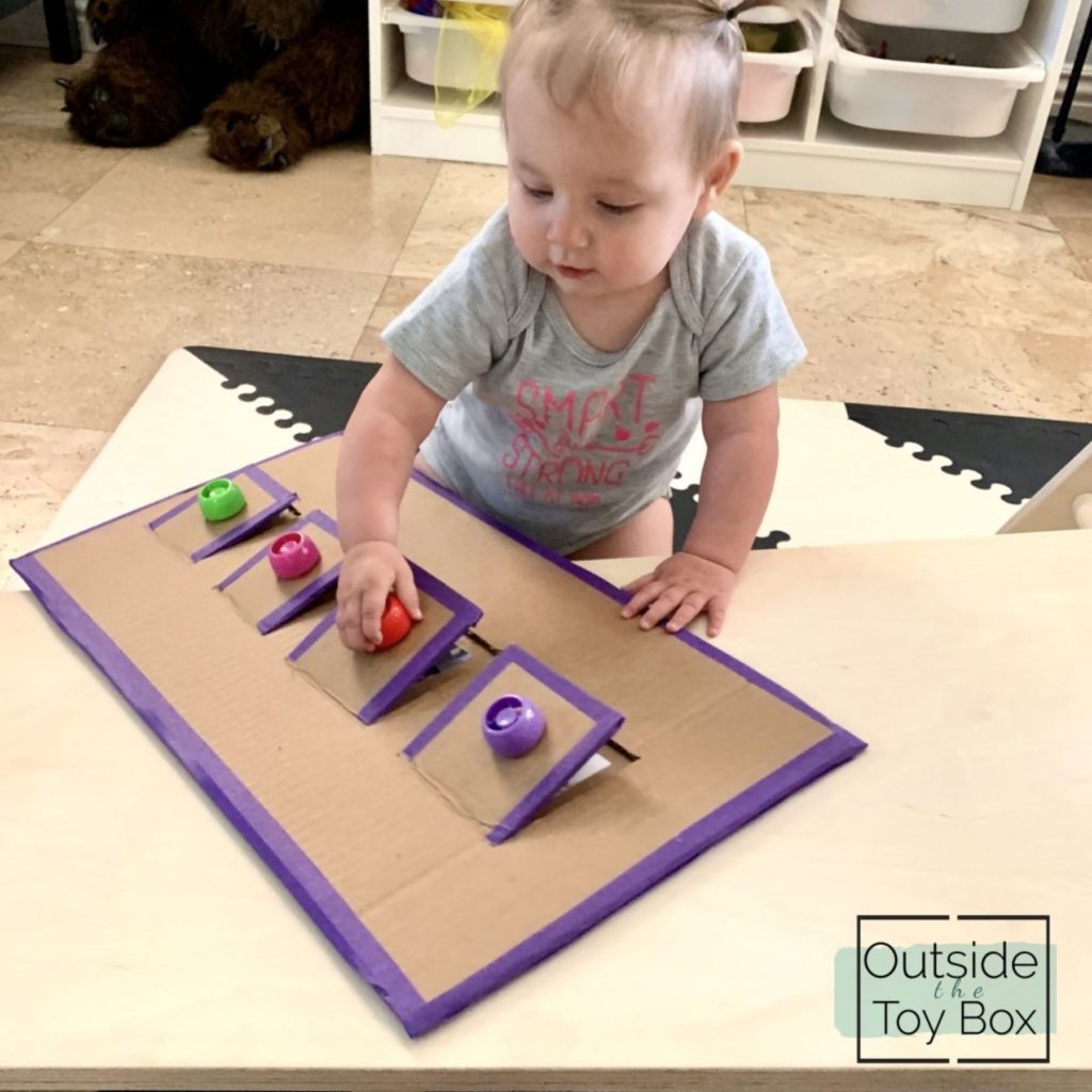 Toddler playing with Cardboard lift flap puzzle