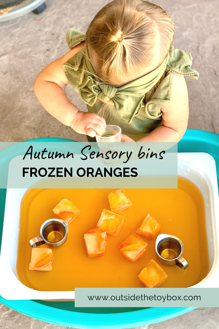 Toddler scooping orange water with frozen oranges