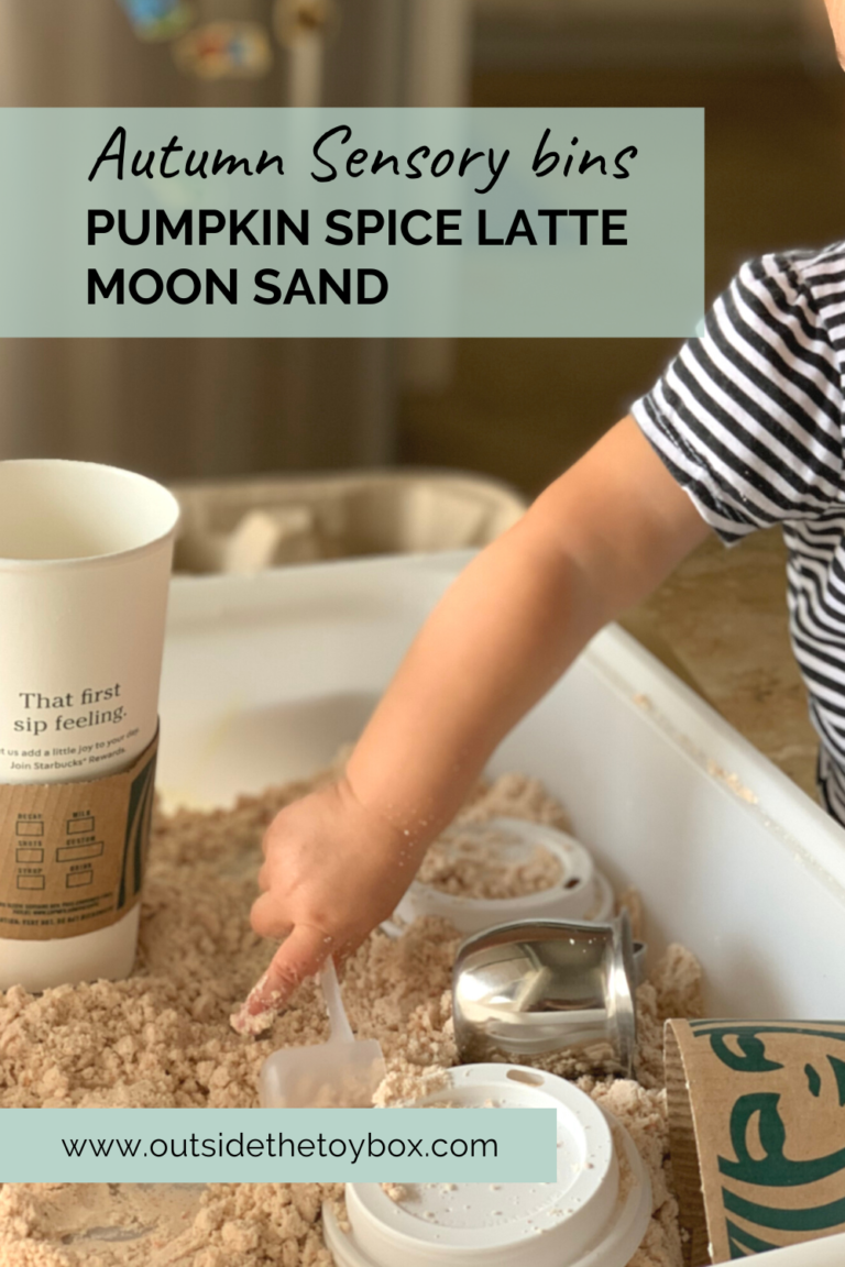 Toddler hand scooping moon sand with Starbucks cups