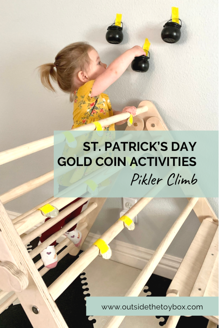 toddler climbing up a Pikler triangle pulling off gold coins and putting them in pots on the wall