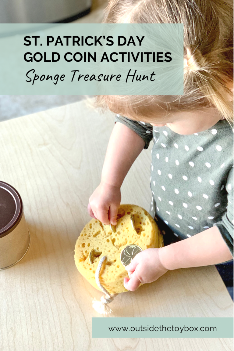 Toddler pulling gold coin from slits in a sponge