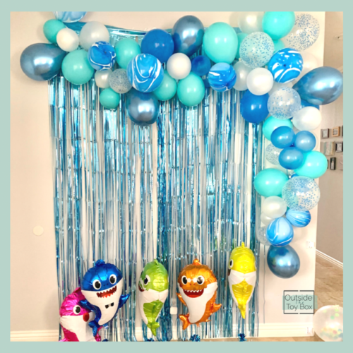 photo op wall with balloon garland and baby shark balloons for second birthday
